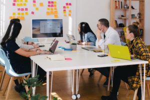 A group of people sitting at a table with a laptop