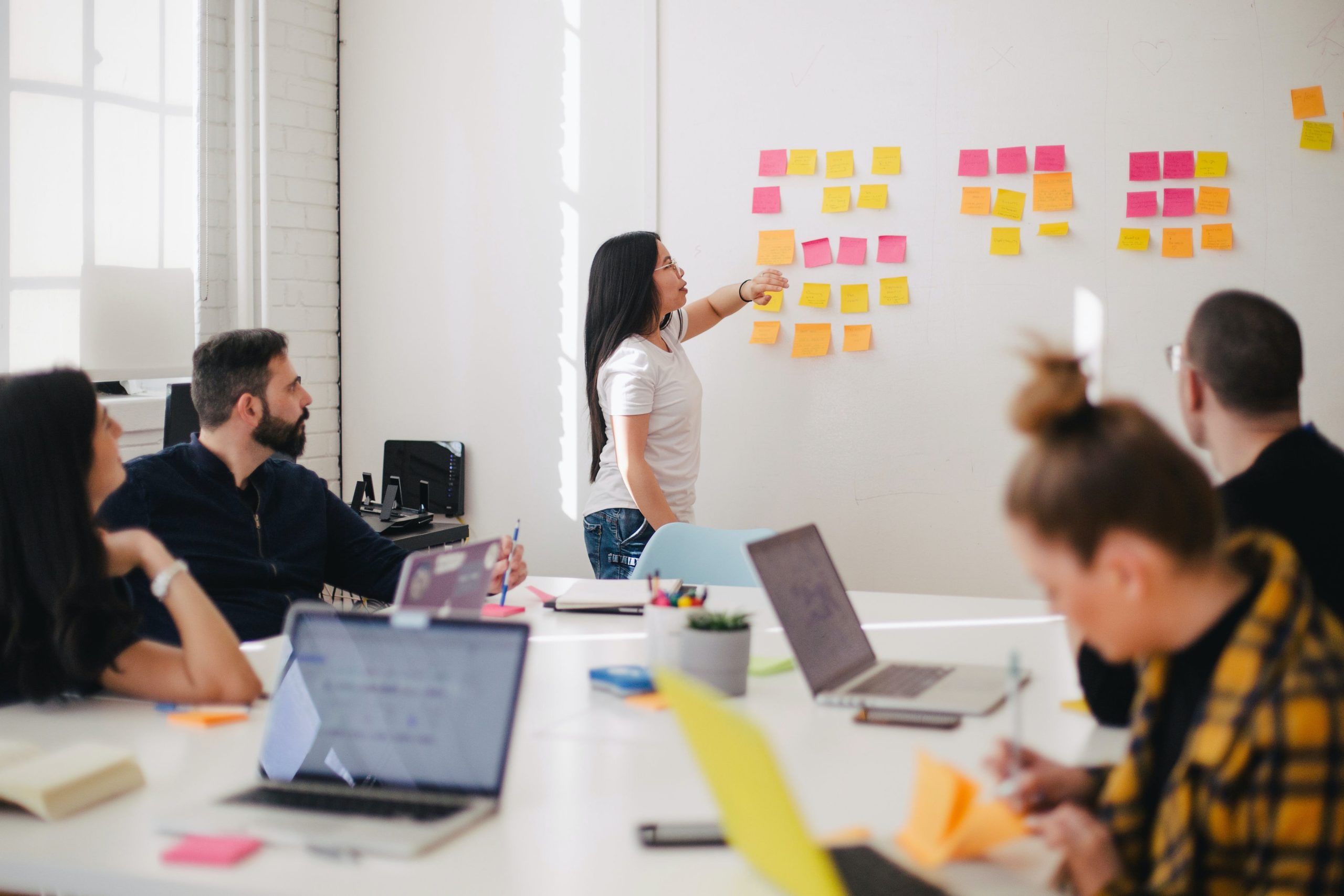 A meeting in a conference room with stickies on the board